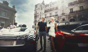 Couple stands between Bugatti and Lamborgini somewhere in Monte